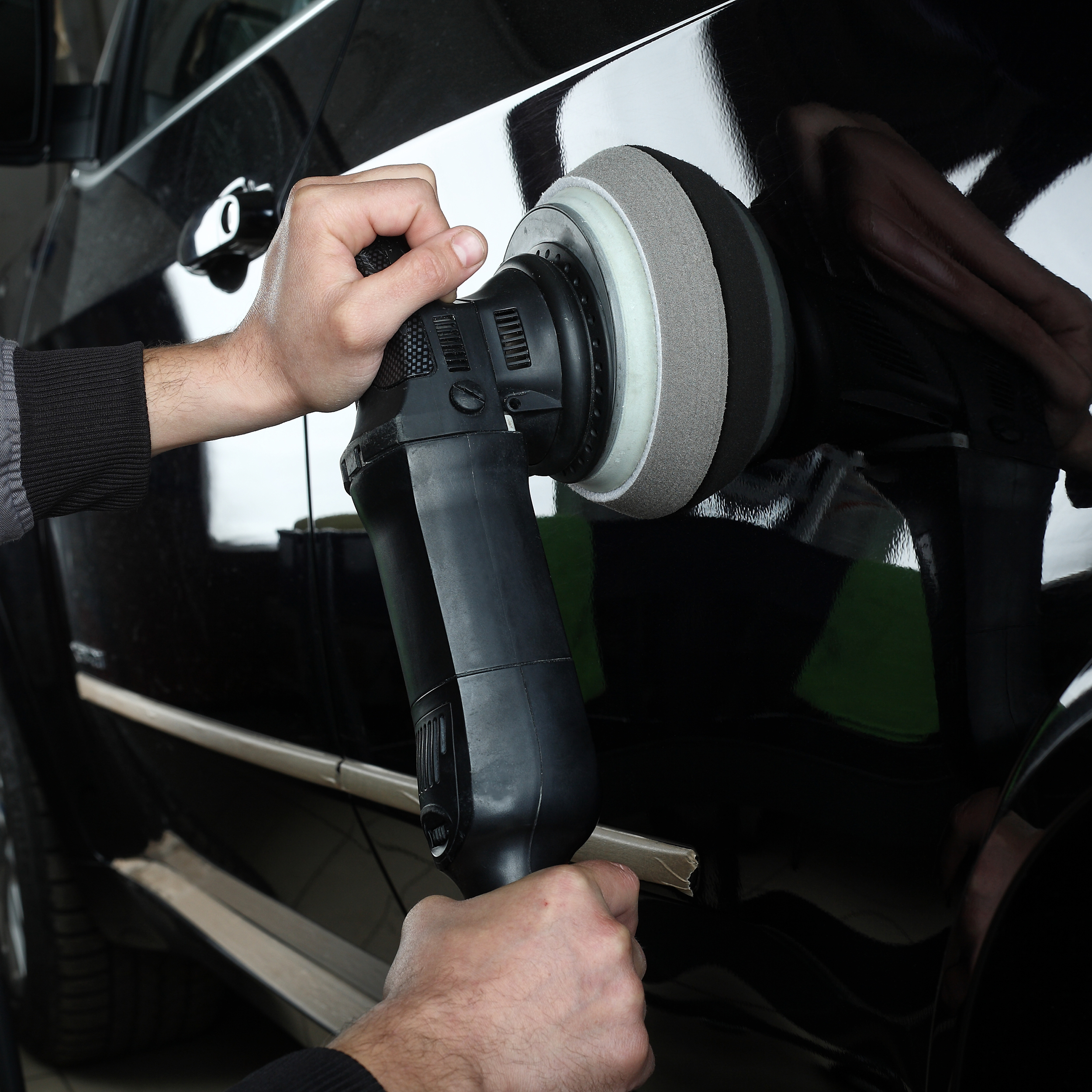 Car service. Worker polishing of the car