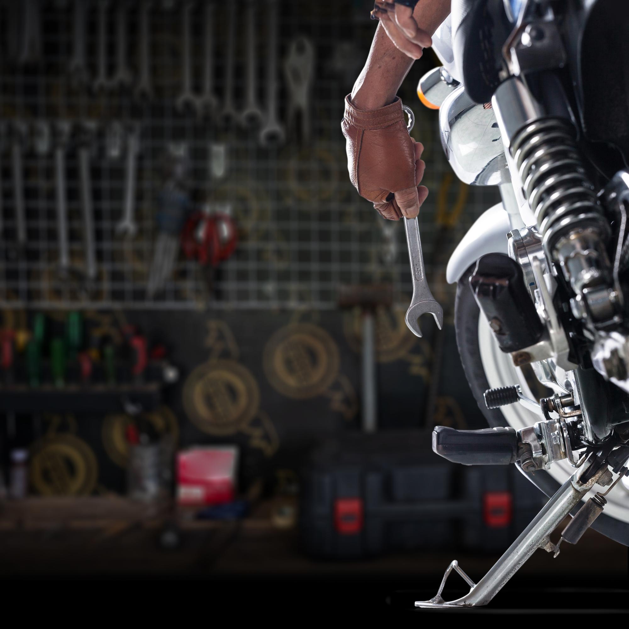 cropped-hand-mechanic-repairing-motorcycle